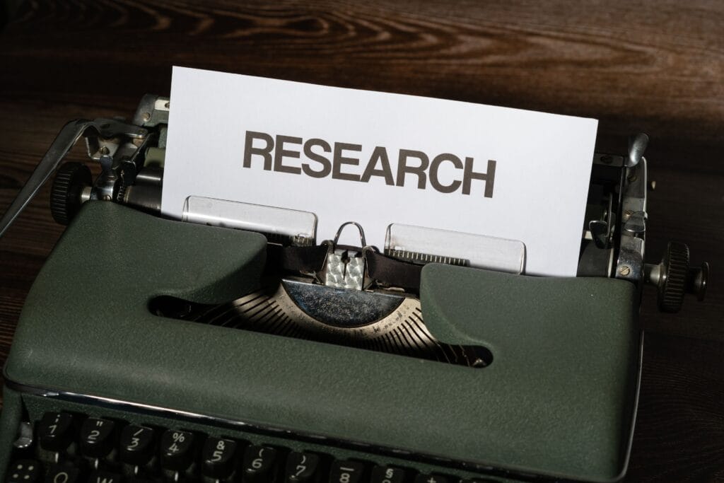 Paper labeled "RESEARCH" inserted into a vintage typewriter.